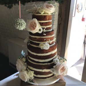 naked wedding cake with fresh flowers